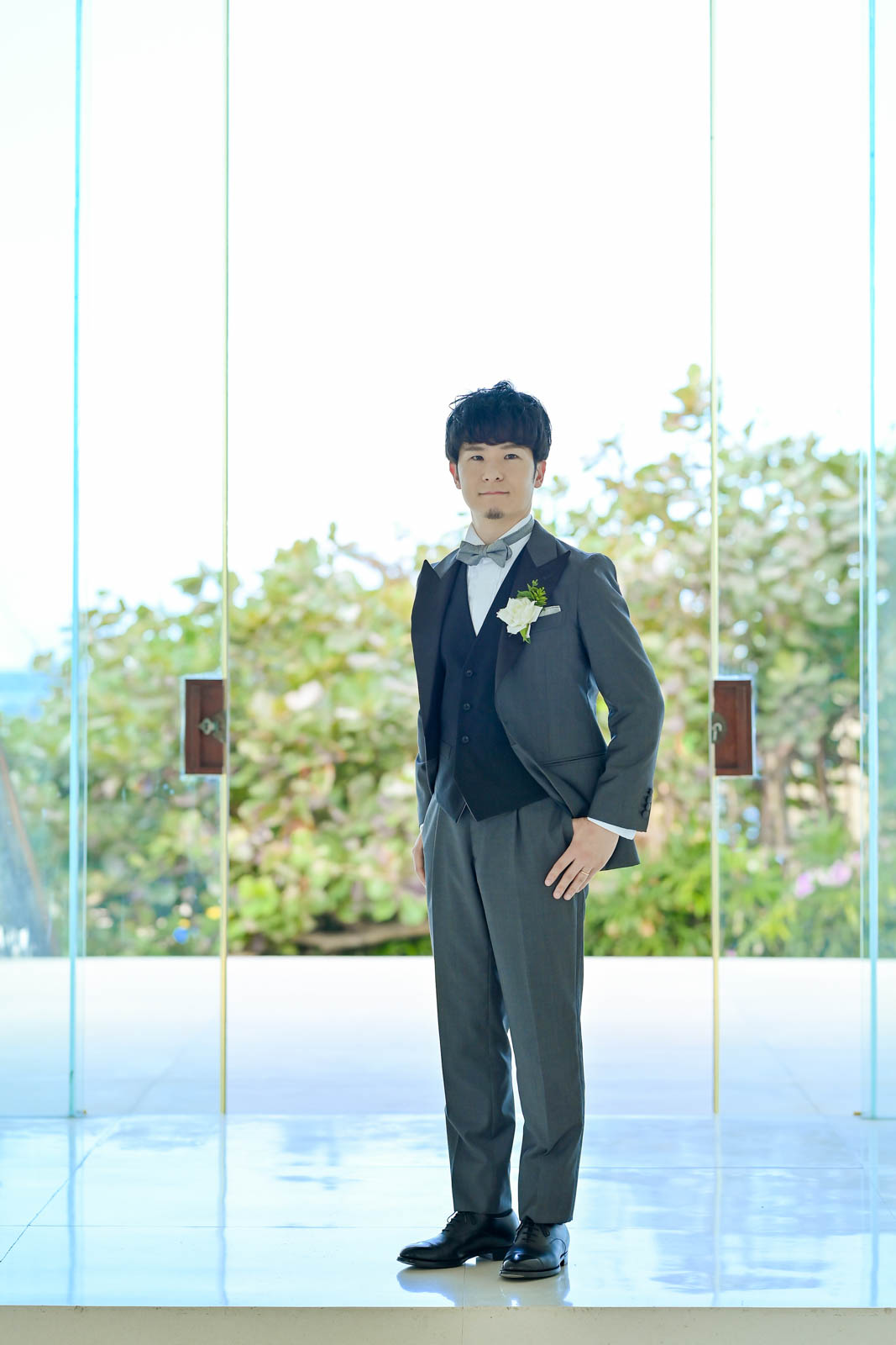 バリ島チャペルで撮影されたグレーのタキシードを着た新郎の全身ポートレート