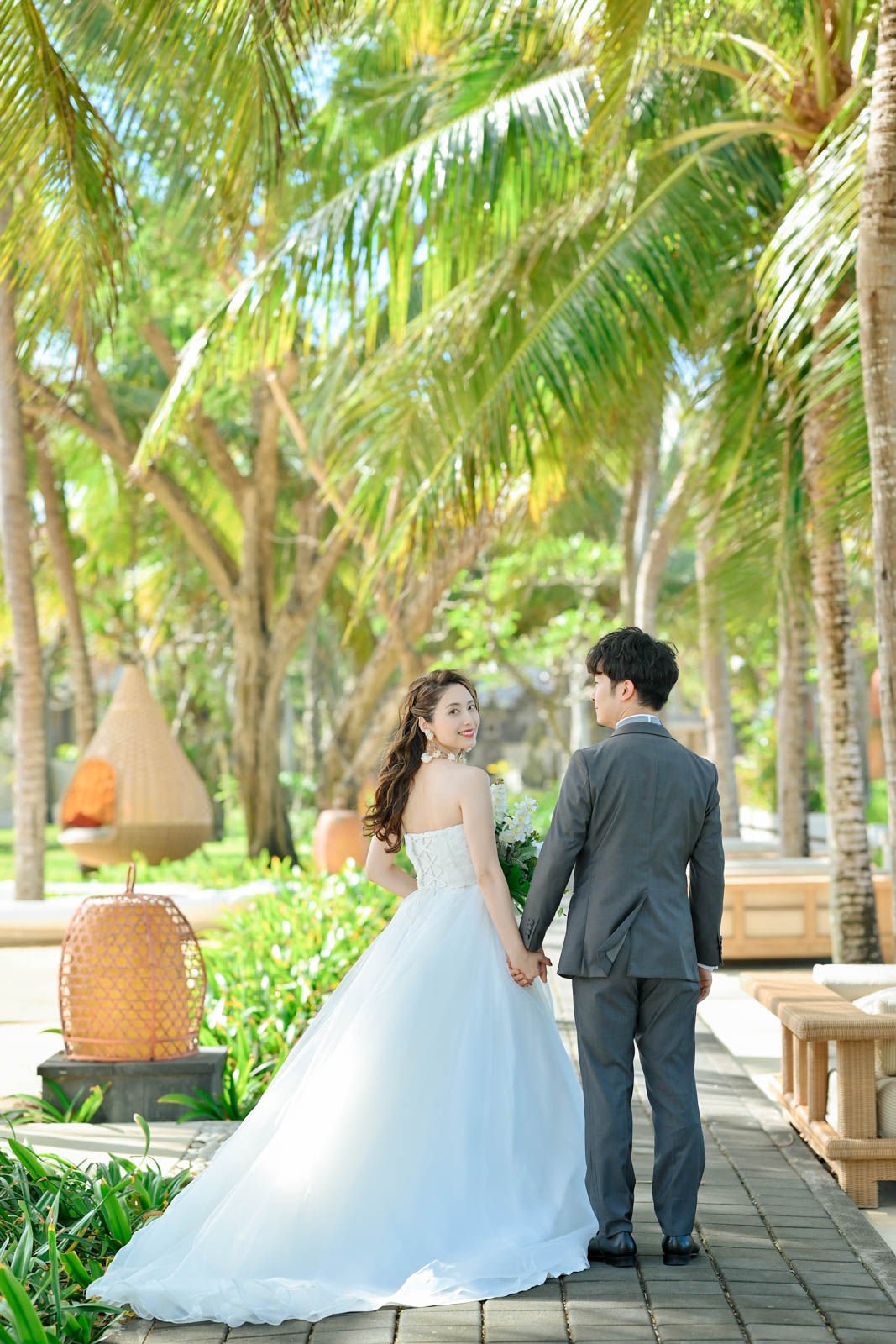 ウルシャンティチャペル周辺のガーデンで手をつなぐ新郎新婦の後ろ姿｜バリ島フォトウェディング