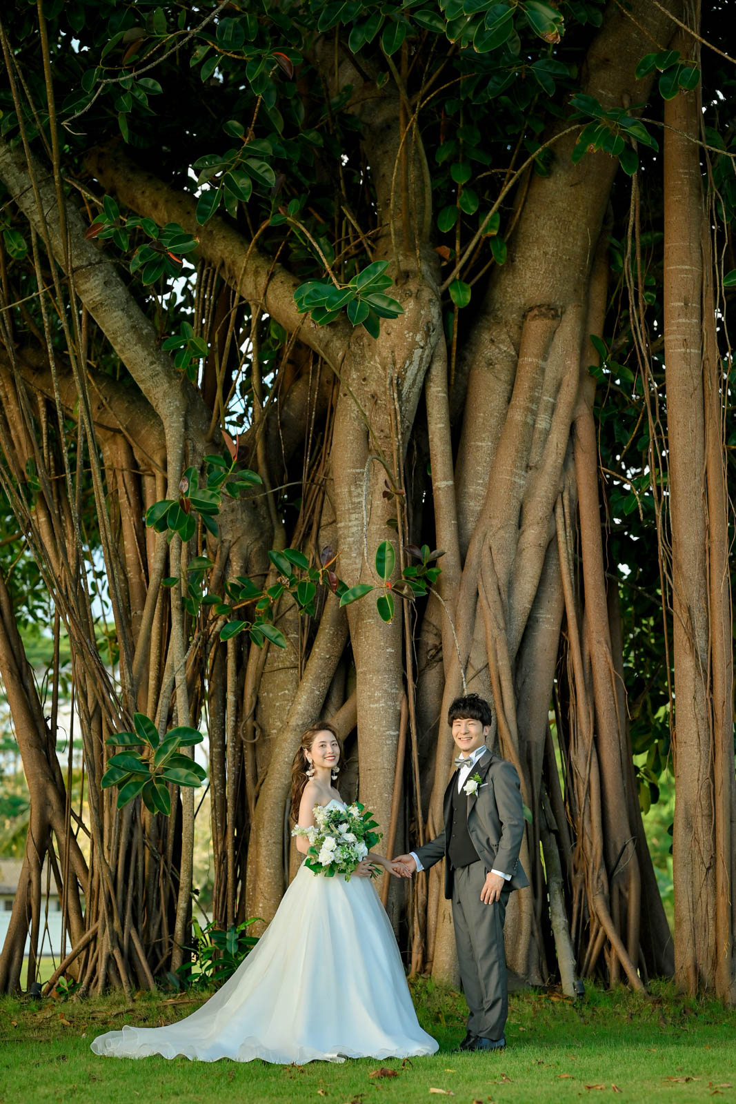 巨大なガジュマルの木の前で手を取り合う新郎新婦｜インターコンチネンタル・バリ・リゾート