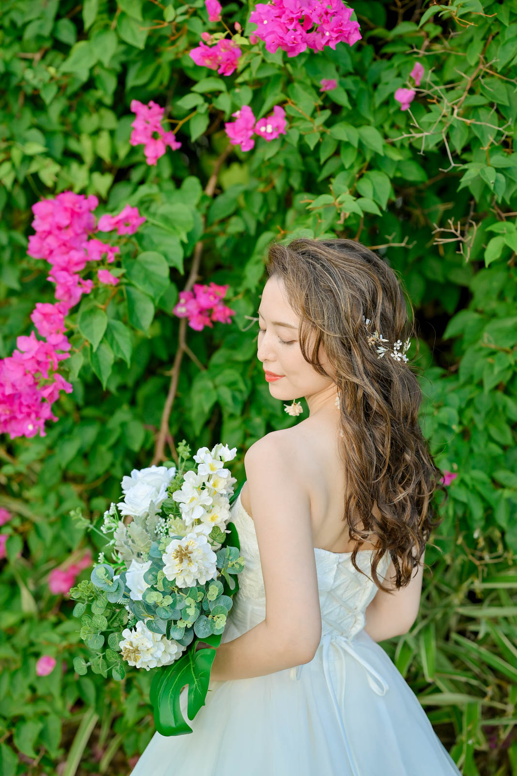 ピンクのブーゲンビリアの前で目を閉じ微笑む花嫁｜インターコンチネンタル・バリ・リゾート