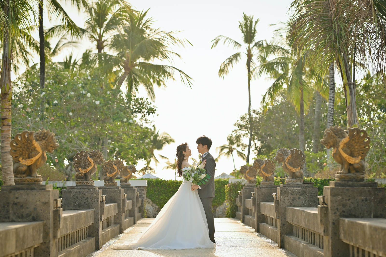 ガルーダ像の橋の中央で見つめ合う新郎新婦｜ジンバランのインターコンチネンタル・バリ・リゾート