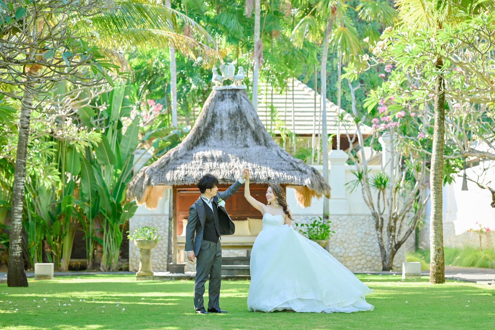 インターコンチネンタル・バリのガーデンで踊るように手を取り合う新郎新婦