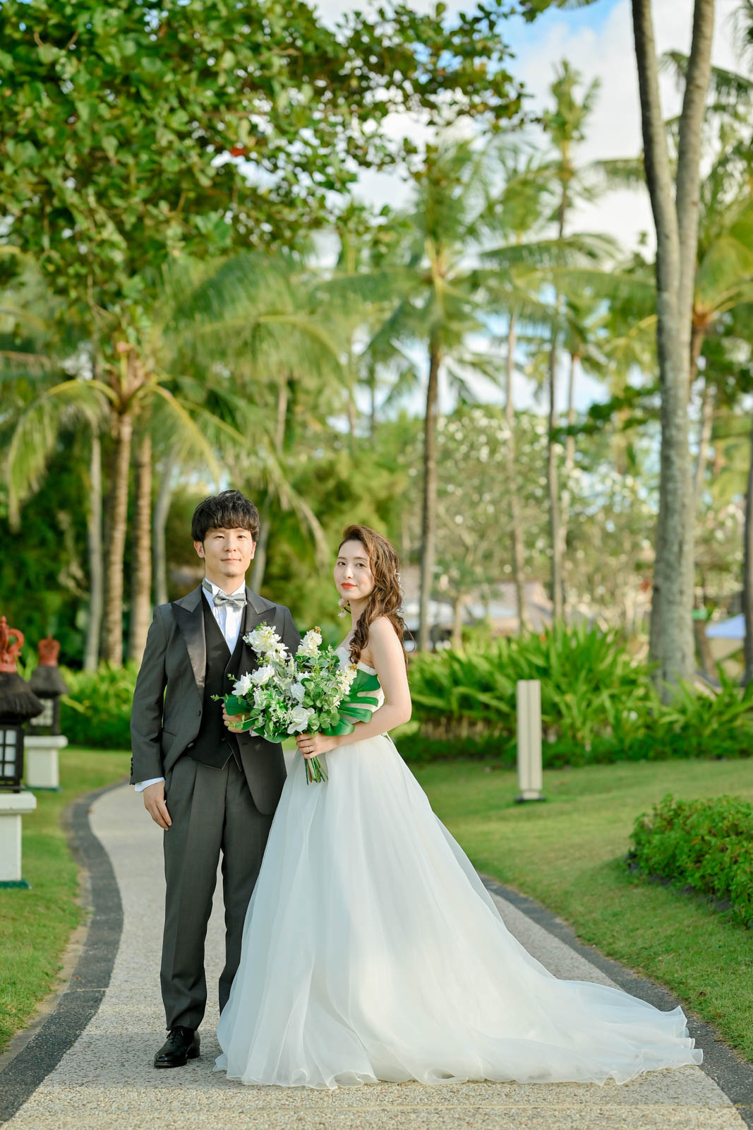 インターコンチネンタル・バリのガーデンでブーケを持つ新郎新婦のポートレート