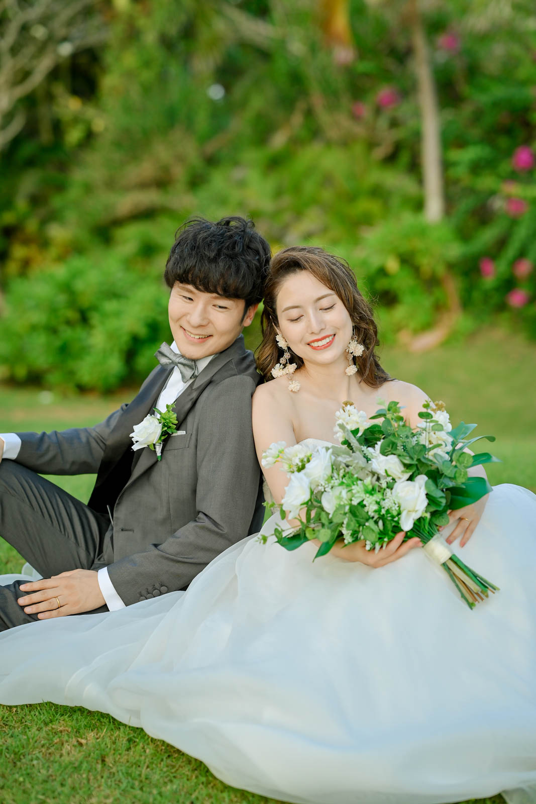 芝生に座って寄り添う新郎新婦のリラックスフォト｜インターコンチネンタル・バリ・リゾート