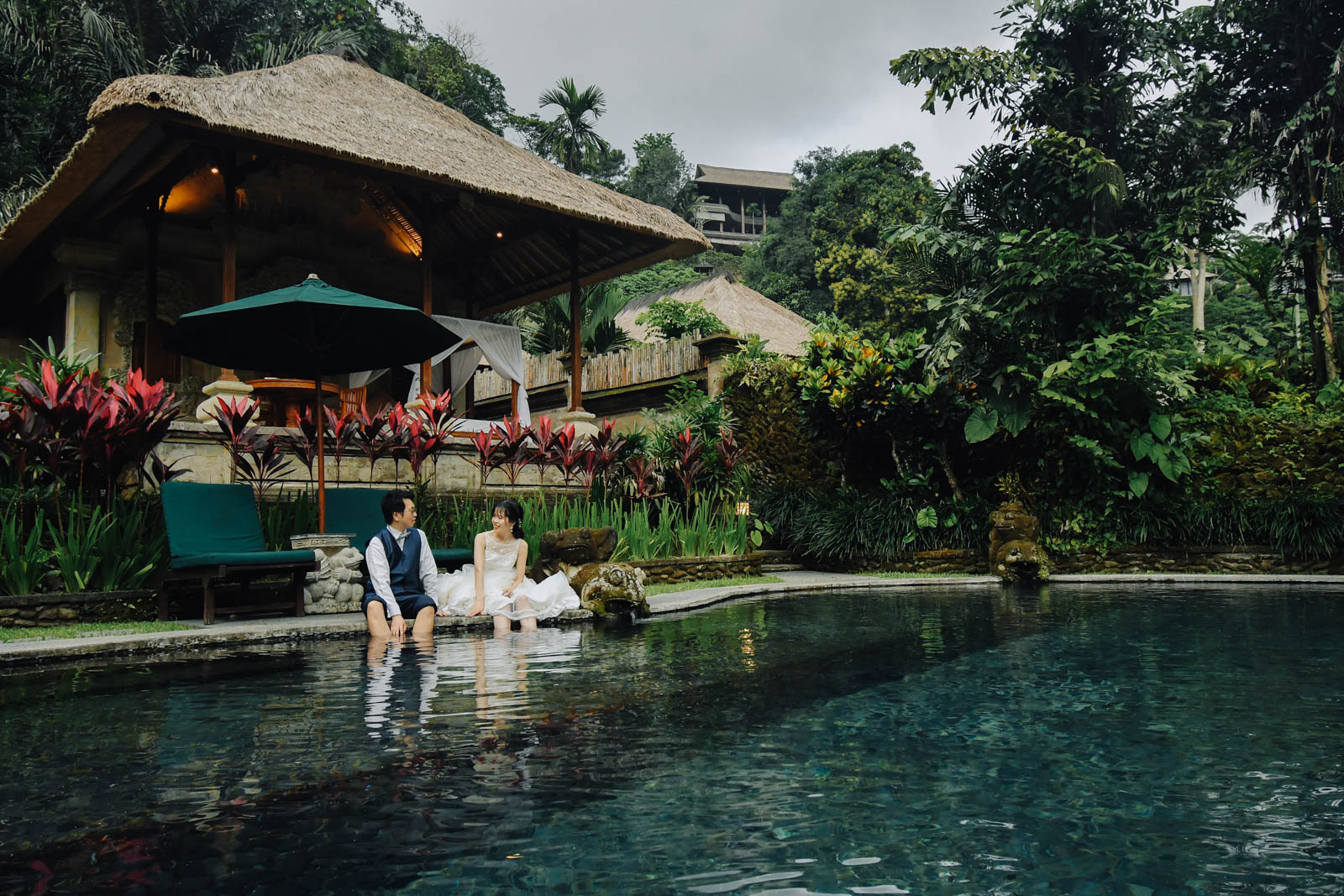 ロイヤルピタマハのプールサイドで座る新郎新婦