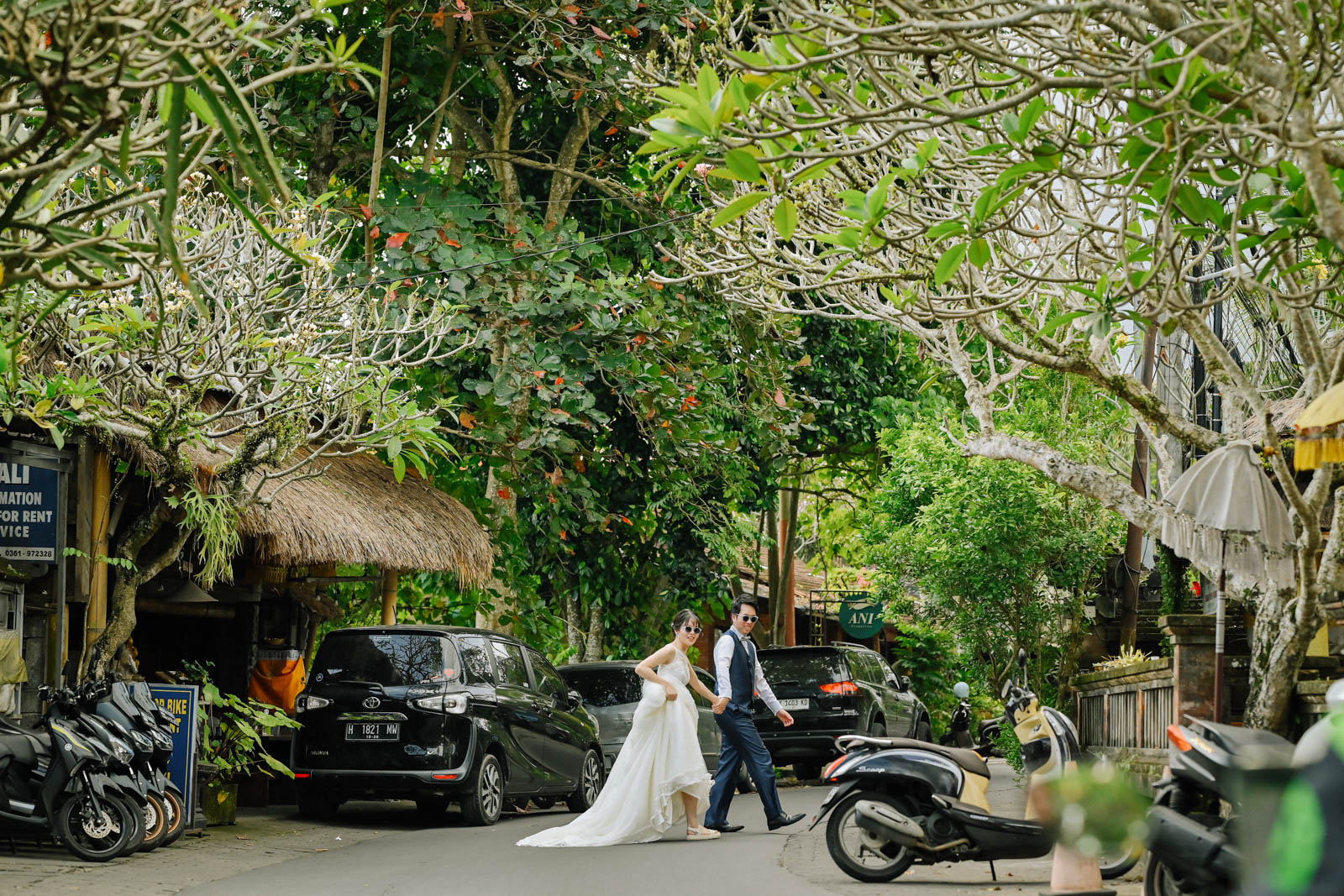 ウブドの街中で手をつないで横断する新郎新婦