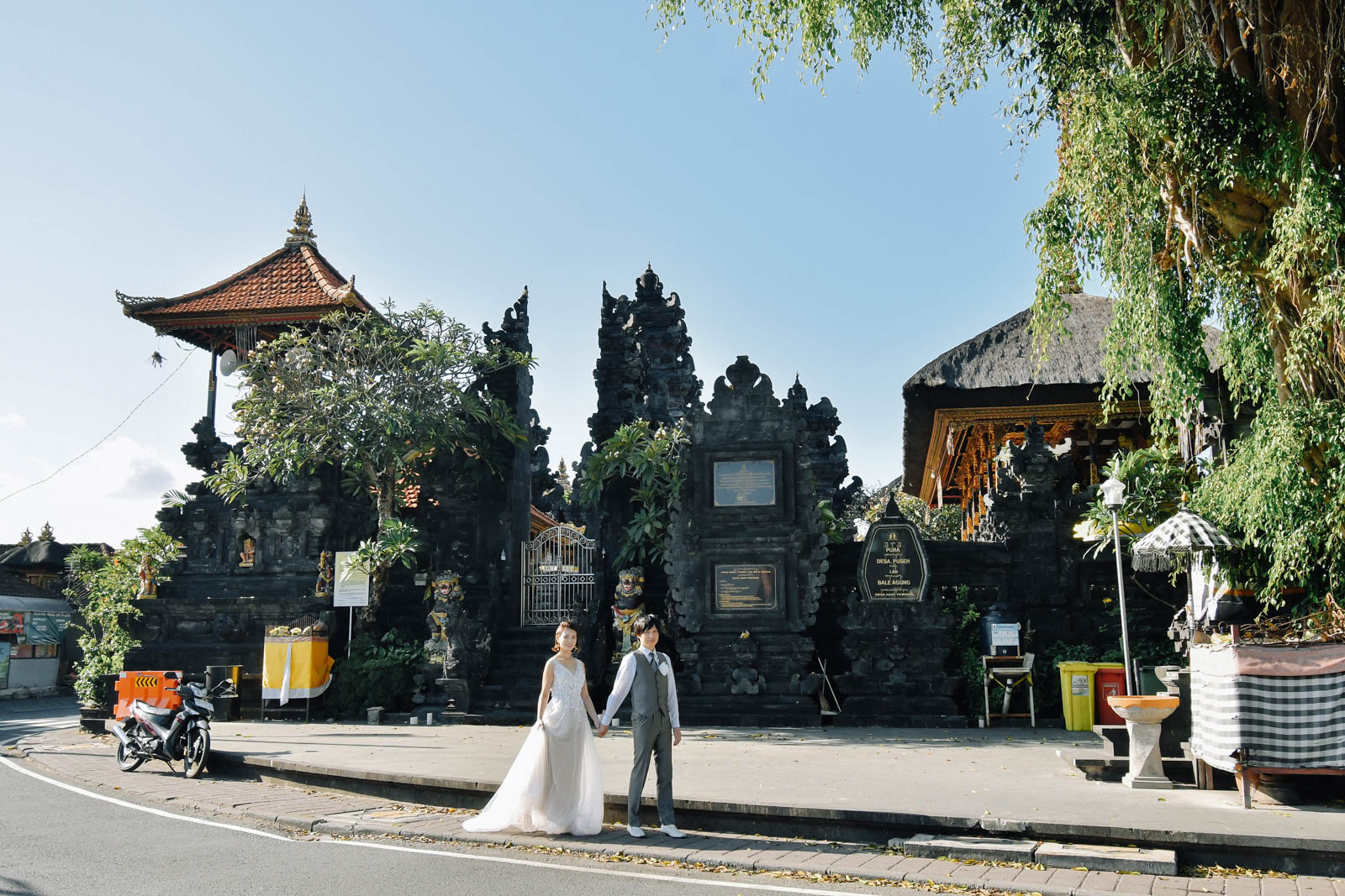 バリ島の寺院を背景に並んで立つ新郎新婦の街フォト