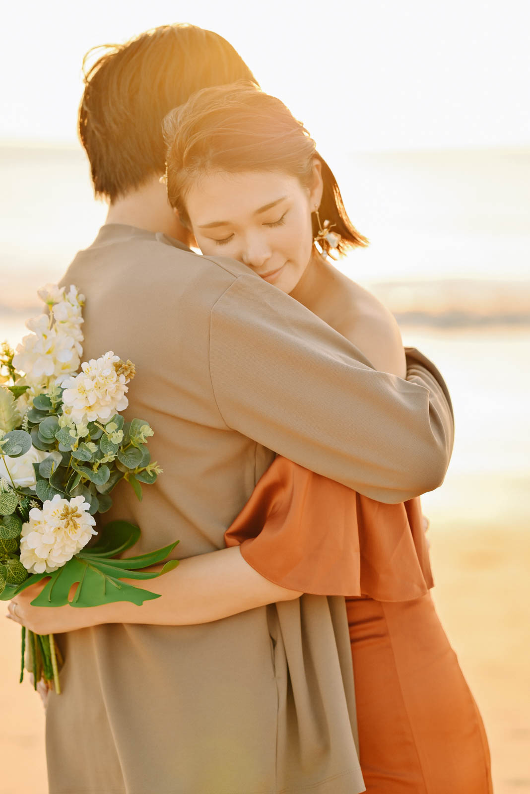 優しくハグするカップルのサンセットフォト