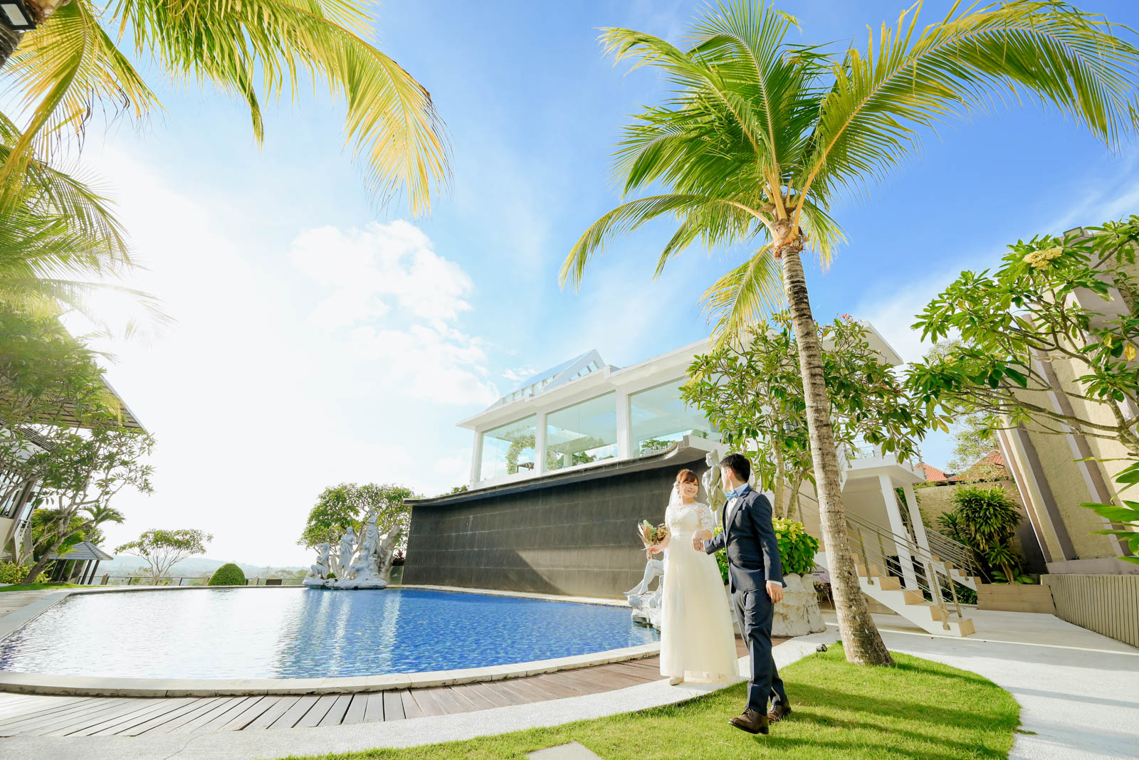 バリ島チャペルのプールサイドを歩く新郎新婦のウェディングフォト