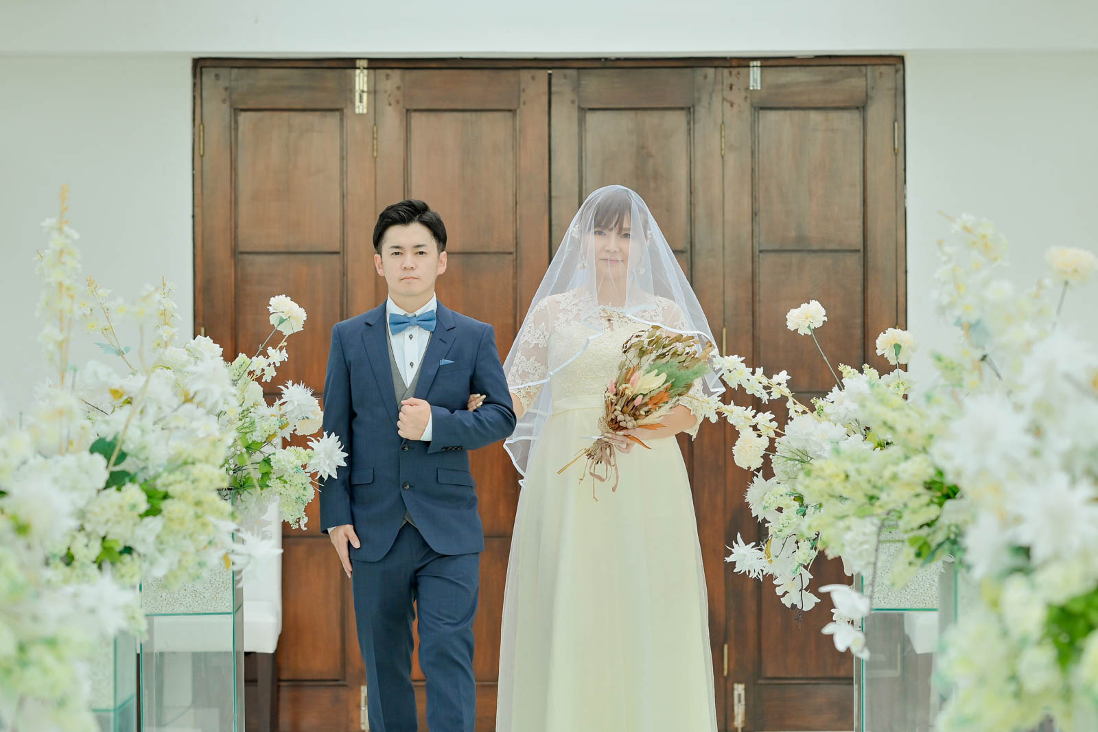 バリ島チャペルで新郎新婦が腕を組んでバージンロードを歩く入場シーン