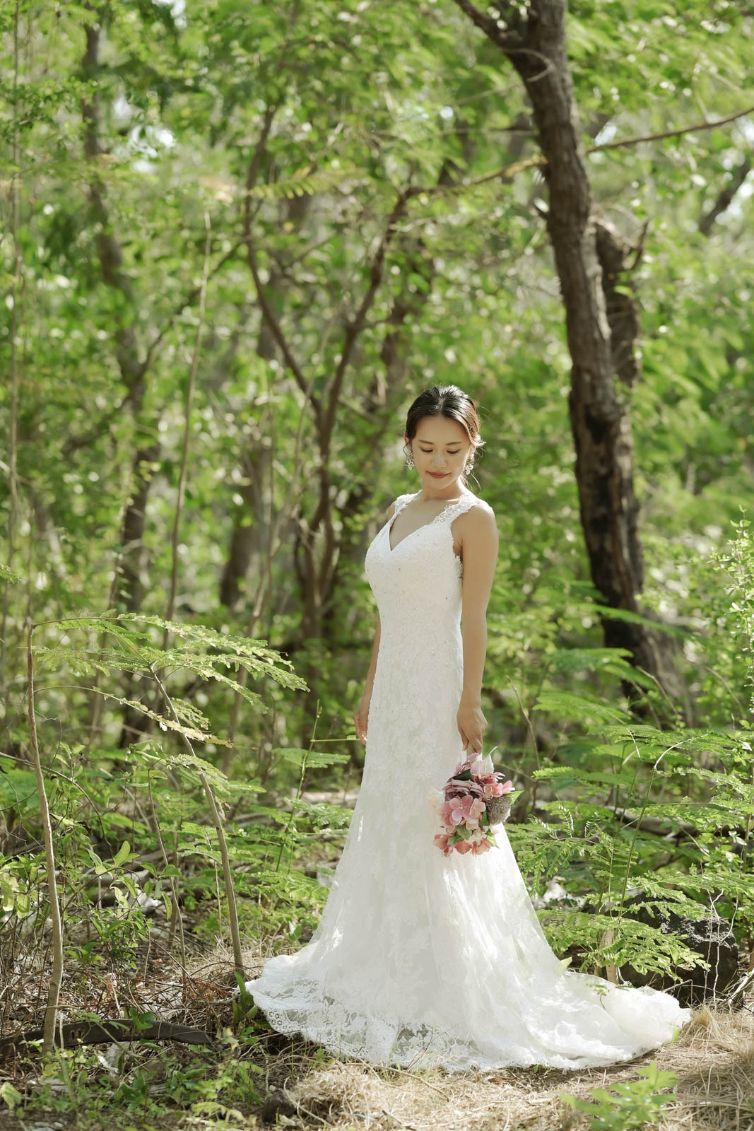 緑の森の中でレースドレスを着た花嫁が微笑むバリ島フォトウェディング