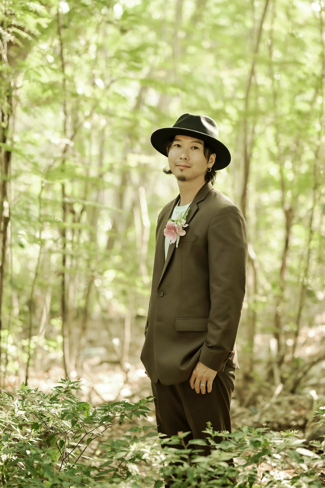 緑の木漏れ日の中で撮影された新郎のポートレート写真