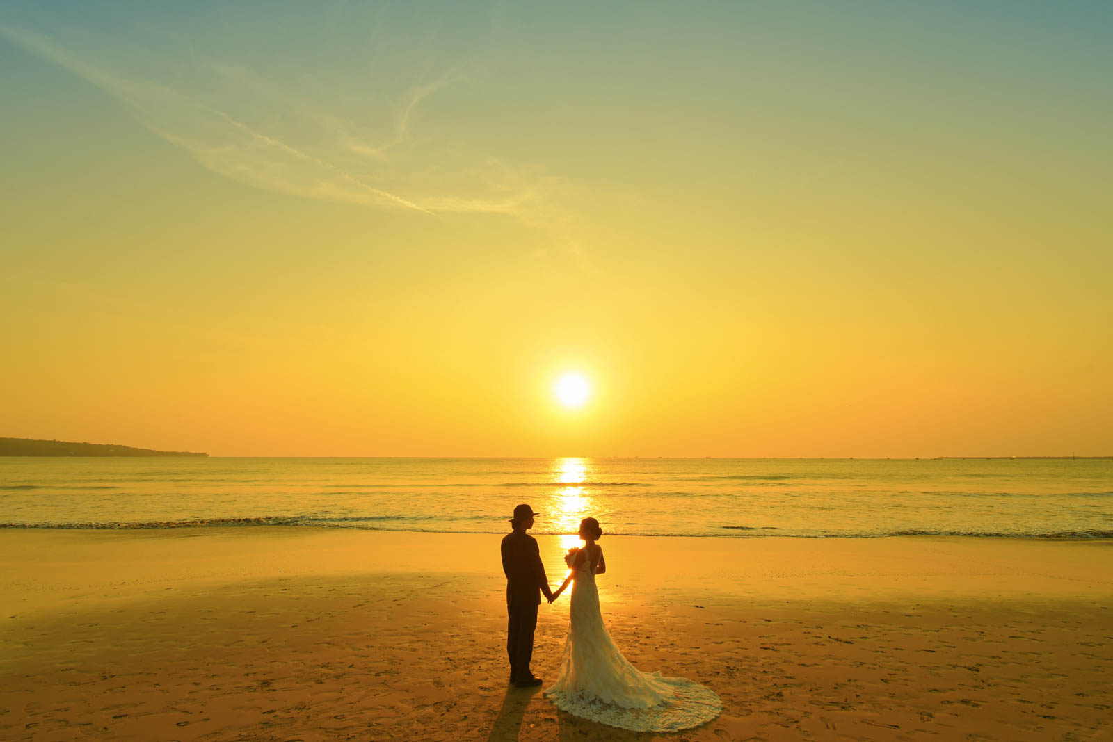 バリ島の夕陽を背に手を取り合うカップルのサンセットフォト