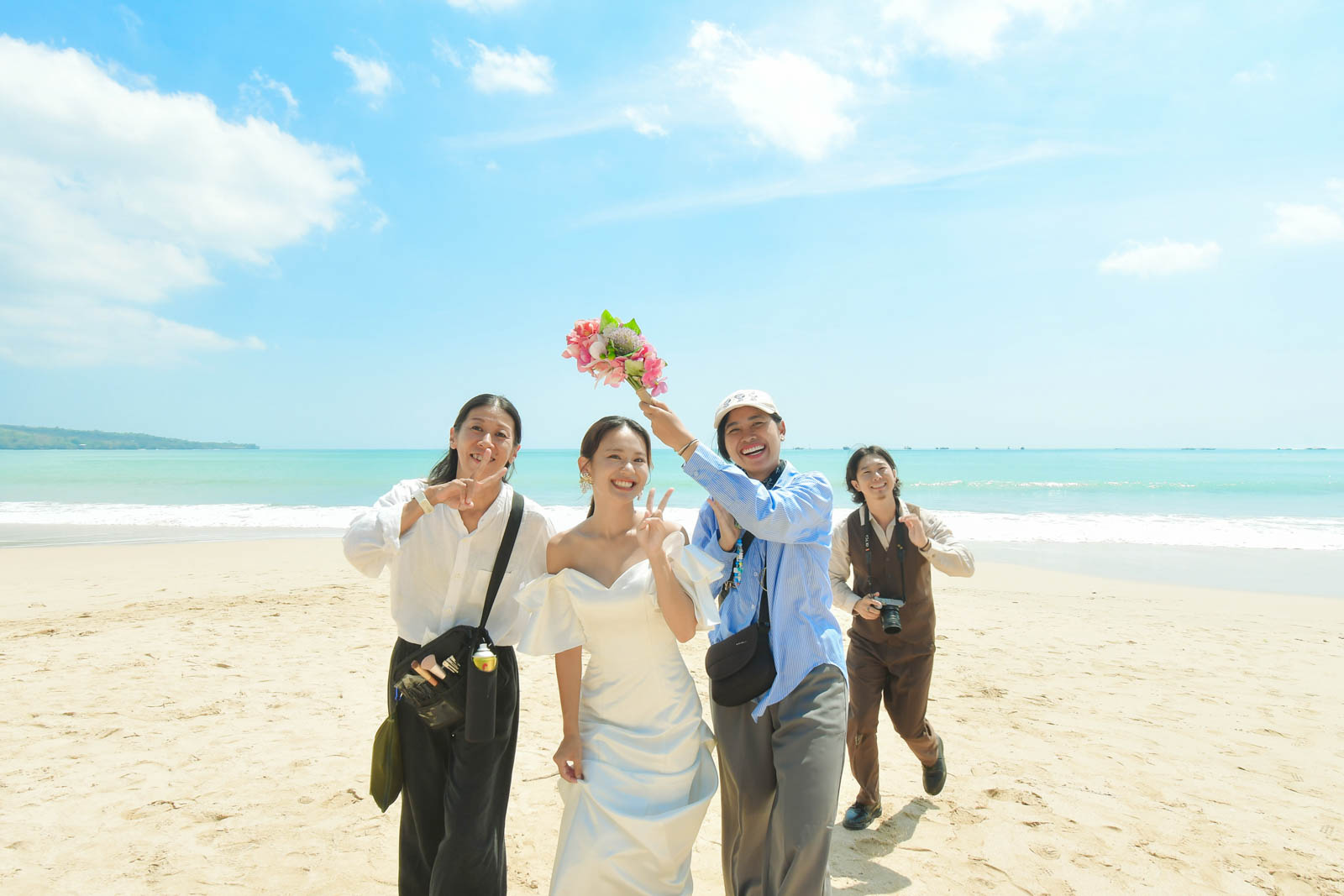 ジンバランビーチでスタッフと一緒に笑顔の記念ショットを撮るシーン