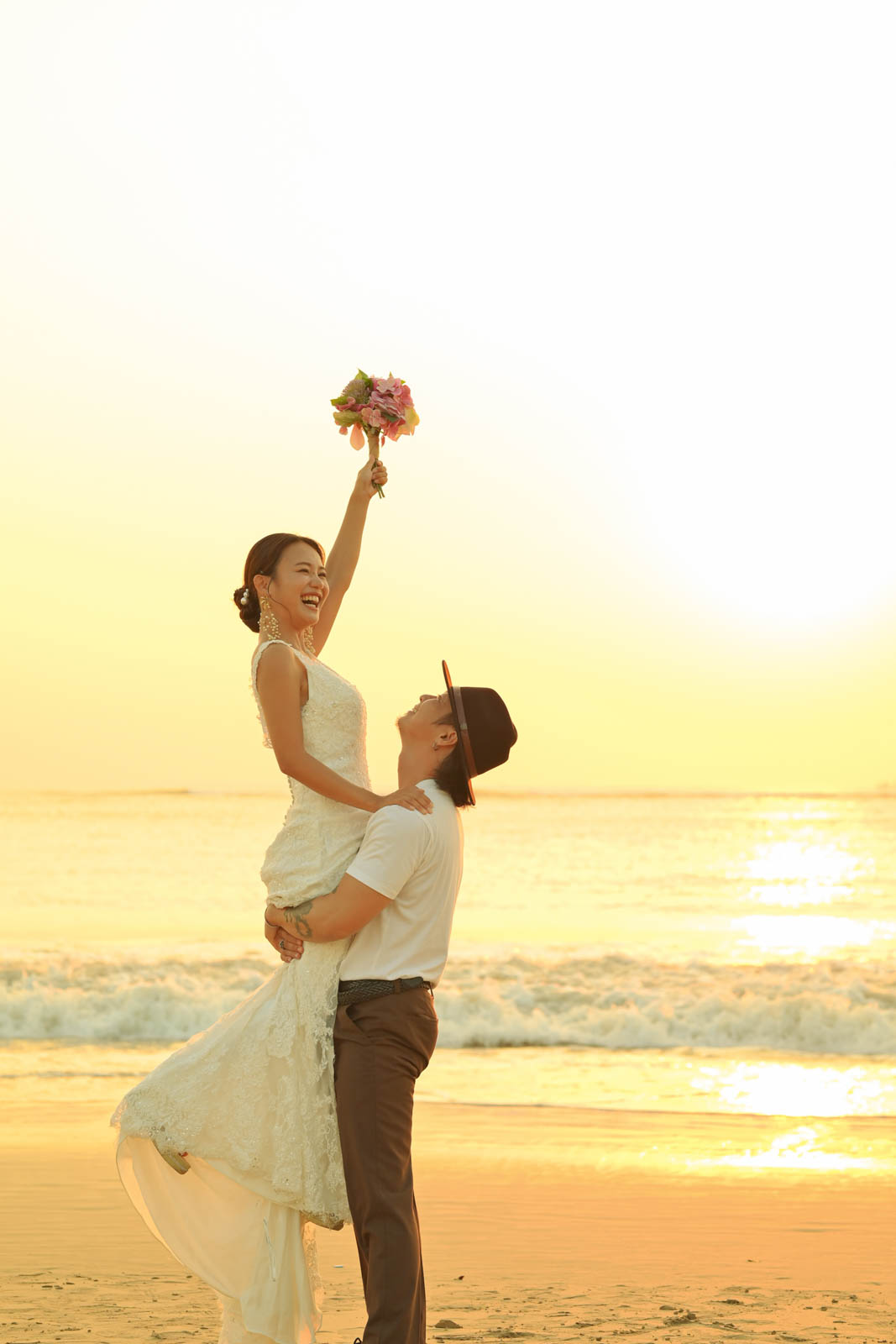 バリ島の海辺で抱き上げショットを撮るカップルのフォトウェディング